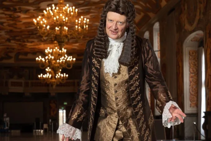Mann mit Perücke in Kleidung aus der Barockzeit